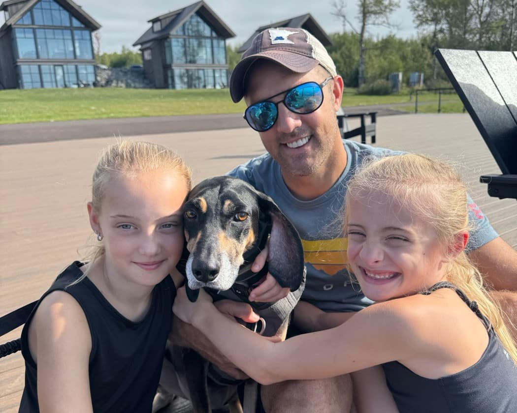 Present: Brian on a dock with his daughters and their dog, everyone smiling, no phone